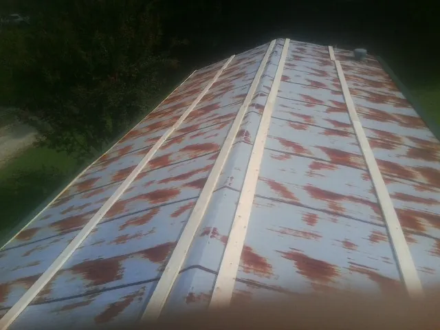 Rusted metal roof panels with new wood purlins before replacement — Storm Damage Roof Repair in Caledonia by Roofing Brothers