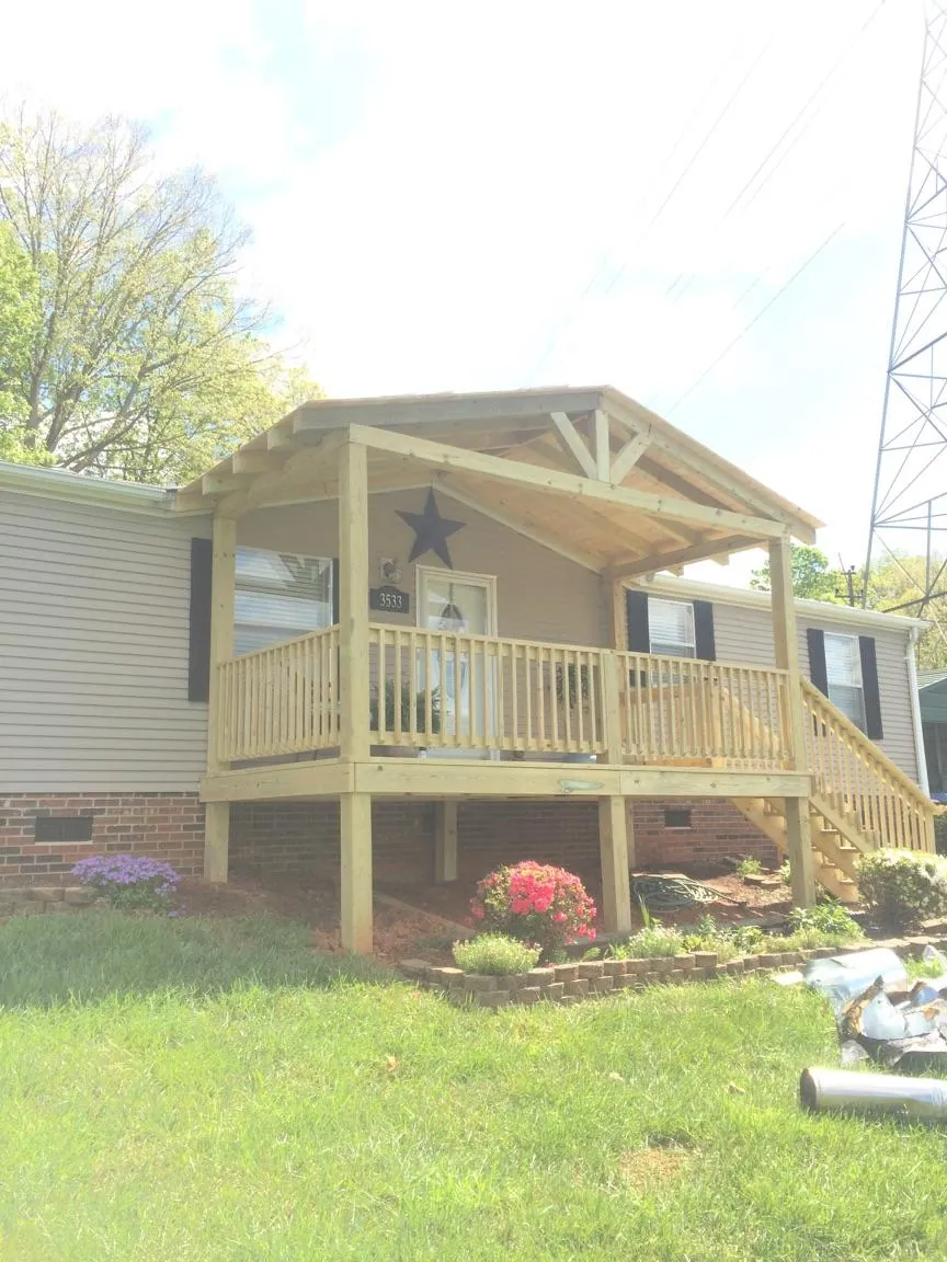 New gabled porch roof and deck railing added to a ranch home in Caledonia